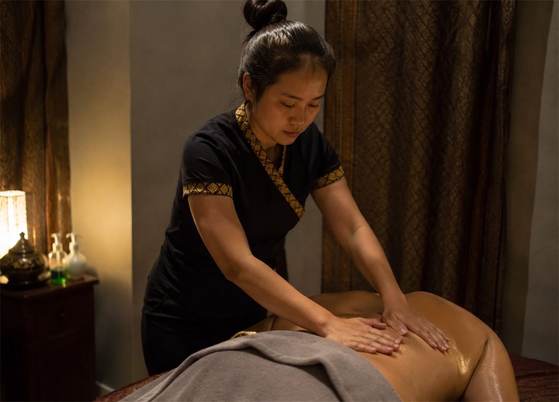 Massage therapist giving a home massage in Thailand